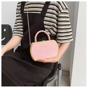 Detail der rosa Leder-Box-Tasche mit goldenem Metallrahmen und Kettenriemen