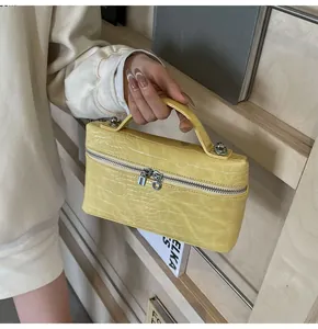 Dettaglio della borsa a scatola in pelle goffrata coccodrillo giallo con cerniera argento