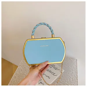 Nahaufnahme hellblaue hexagonale Handtasche mit Goldrahmen und gedrehtem Seilgriff