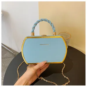 Detail der hellblauen Box-Handtasche mit Goldrahmen und gedrehtem Seilgriff