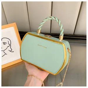 Detailansicht der minzgrünen Box-Tasche mit goldener Kette und gedrehtem Henkelgriff