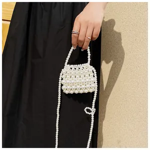 Detailweergave van een handgemaakte mini-pareltas met handvat en crossbody ketting