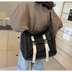 Detailed back view of a large black canvas messenger bag with adjustable strap and buckles