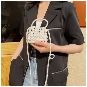 Detailopname van een witte parel mini-tas met gestructureerd handvat en ketting