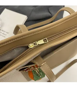 Detailed shot of golden hardware zipper and canvas leather texture on tote bag