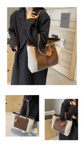 Detail of canvas tote bag with brown leather trim and handmade persimmon charm