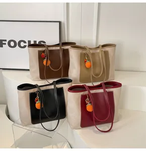 Detailed view of canvas tote bags in four colors with leather pockets and orange charms