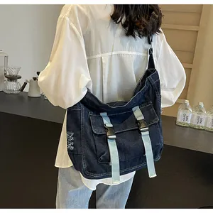 Detail of vintage navy denim messenger bag with adjustable light blue straps and buckles