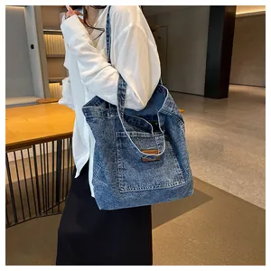 Detail of blue denim tote bag with textured snowflake wash and front decorative patch
