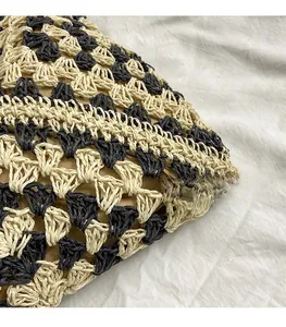 Detail view of woven straw tote bag featuring geometric patterns and inner lining