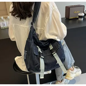 Detail of blue denim messenger bag showing adjustable strap and buckle closure