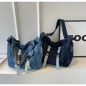 Close-up of vintage denim messenger bags in light and dark blue with frayed fringe detail