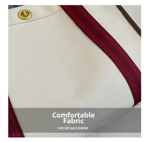 Detail der Canvas-Tasche mit goldenem Drehverschluss und gestreiftem Stoffschultergurt