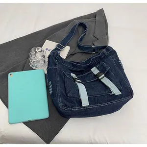 Detail of dark blue denim messenger bag with buckle closure and stylish distressed texture