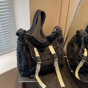 Japanese style black canvas messenger bag with contrast stitching and double buckle pockets
