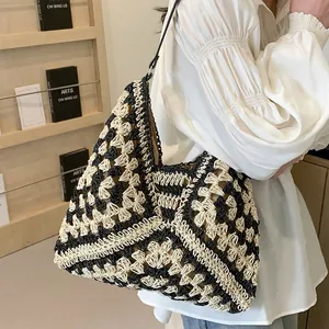 Detail of crochet tote bag with geometric pattern and black leather shoulder strap