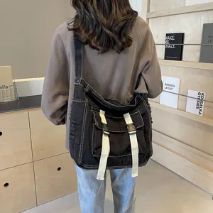 Black canvas messenger bag with white contrast stitching and large capacity for students