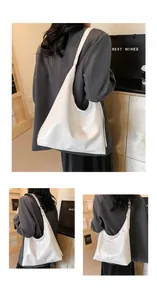 Détail du grand sac hobo blanc montrant la texture du cuir souple et la large bandoulière