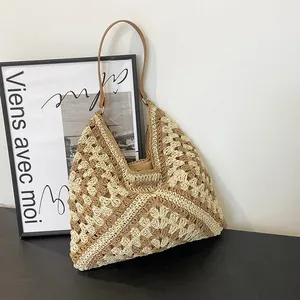 Detailed close-up of handmade crochet hobo bag with hollow pattern and leather straps