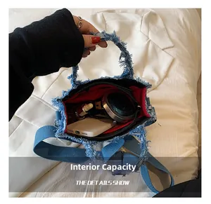 Internal capacity of blue denim tote bag with red lining and small zipper pocket