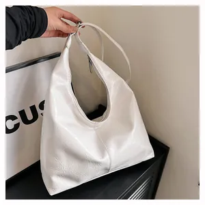 Détail du sac hobo blanc crème montrant le cuir texturé froissé et la bandoulière élégante