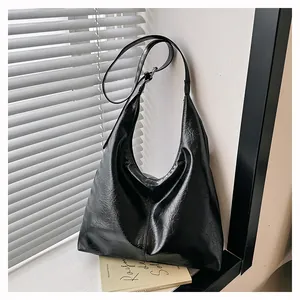 Gros plan sur la texture du cuir plissé noir d'un sac à main fourre-tout hobo