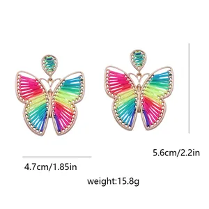 Detalle de pendientes de mariposa con altura de 5,6 cm y tejido de seda multicolor