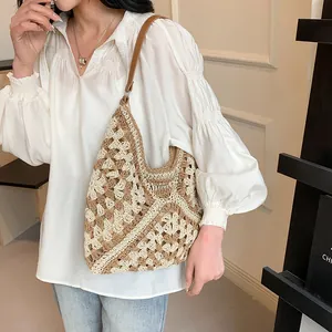 Detail of bohemian hollow crochet hobo bag with brown leather strap in modern interior