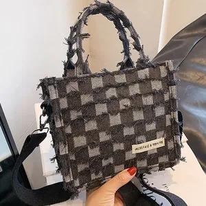Classic black and white checkered tote bag with fringe edges and wide shoulder strap
