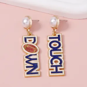 Detail of TOUCH DOWN letter earrings with faux pearls and rugby football charms