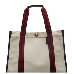 Grote canvas shopper met bordeauxrode banden en bruine leren bies op witte achtergrond