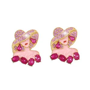 Dettaglio degli orecchini dorati con silhouette di donna e cristalli rosa