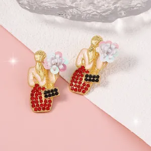 Dettaglio di orecchini di lusso con abito in strass rossi e decorazioni floreali