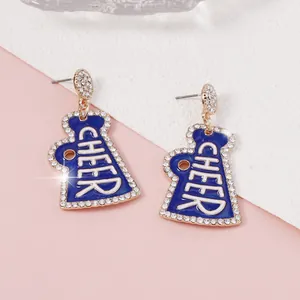 Dettaglio macro di orecchini megafono in smalto blu con cristalli e scritta CHEER