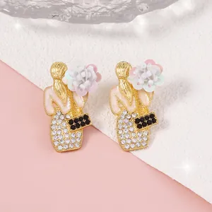 Dettaglio di orecchini floreali con strass brillanti e silhouette femminile elegante
