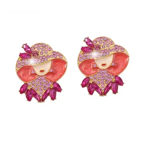 Dettaglio degli orecchini da donna eleganti con smalto rosso e cristalli rosa