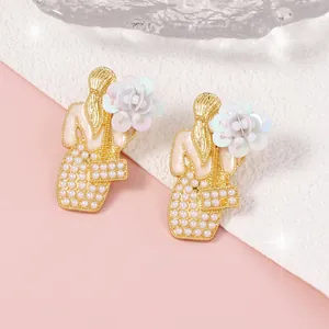 Orecchini a silhouette dorata con cristalli colorati e perle dal design bohémien