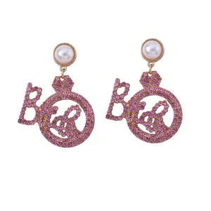 Auffällige Goldohrringe mit rosa Strasssteinen, Perlenakzenten und Bride-Buchstaben