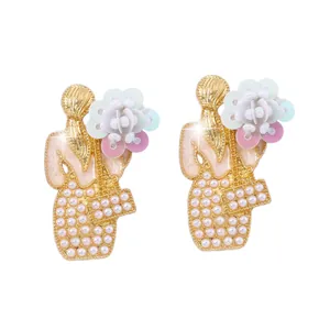 Dettaglio di orecchini floreali con elegante figura femminile, perle e paillettes