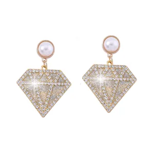 Detalle de pendientes de rombo con cristales brillantes y perla de estilo moderno