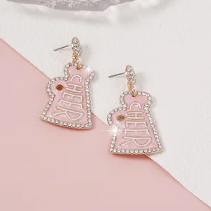 Dettaglio degli orecchini a megafono rosa con strass e finiture in finta perla