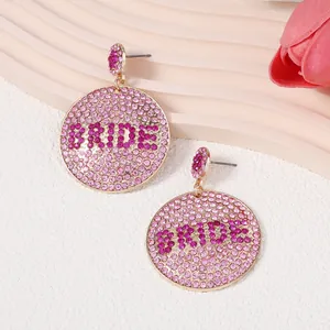 Detailansicht der runden rosa Strassohrringe mit magentafarbenem BRIDE Schriftzug für Hochzeiten