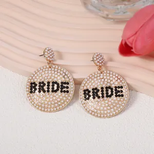 Goldene Braut-Ohrringe mit weißen Perlen und BRIDE-Schriftzug aus Strass