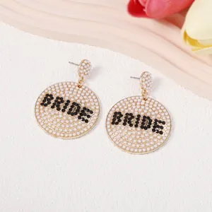 Detailaufnahme der BRIDE Ohrringe mit weißen Perlen und goldener Metalloberfläche