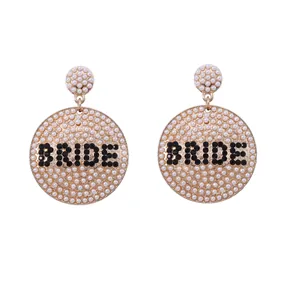 Goldene runde Ohrhänger mit weißen Perlen und schwarzem Strass-Schriftzug BRIDE
