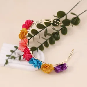 Close-up of golden floral U-shaped headband with multi-colored fabric flowers for women