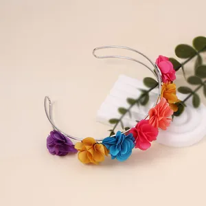 Detail of colorful fabric flowers on a silver metal U-shaped headband for women