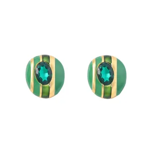 Primer plano de pendientes de rayas doradas con esmalte verde y gema ovalada