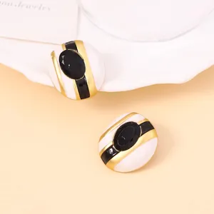 Detalle de pendientes ovalados vintage con esmalte de rayas verdes y piedra negra incrustada