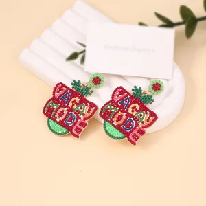 Handmade Vacay Mode colorful seed bead earrings on a stylish white display stand